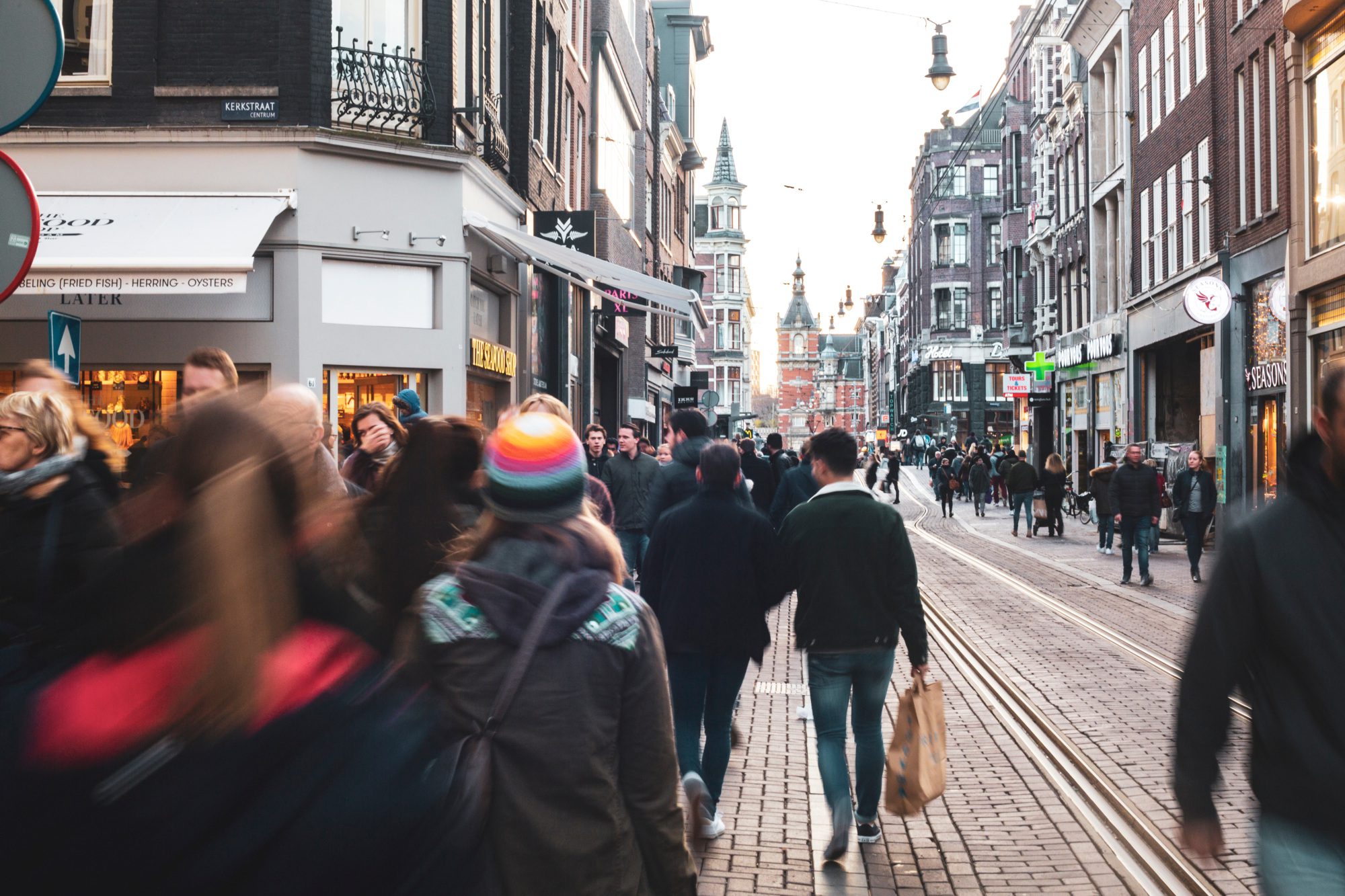 People walking through city of Amsterdam